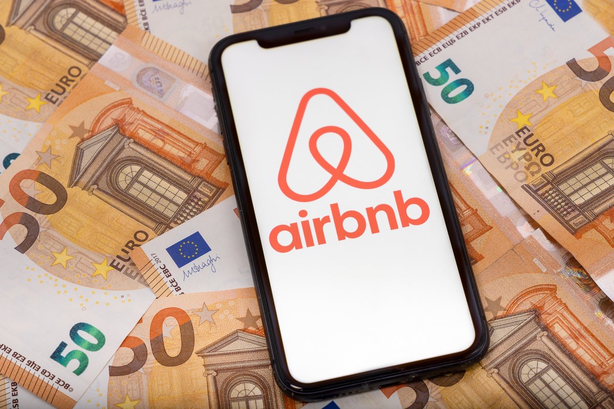 Un smartphone, déposé sur des billets de 50 euros, avec le logo Airbnb © Pixavril / Shutterstock