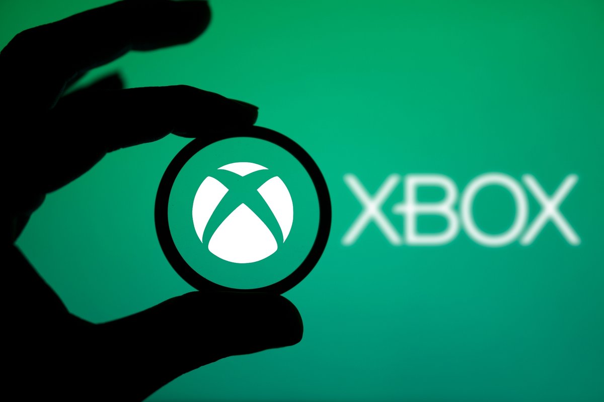 Une personne tenant une loupe pour inspecter le logo de la Xbox © Mojahid Mottakin / Shutterstock.com