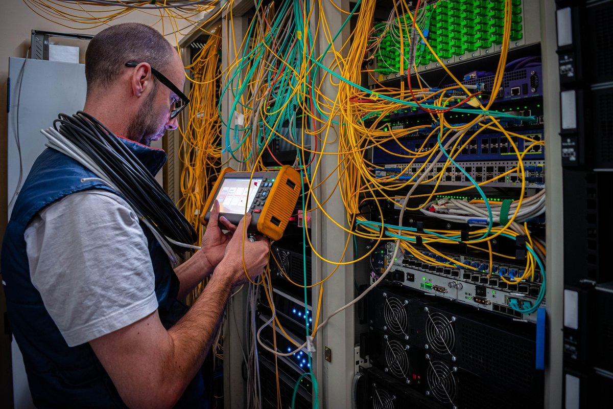 Un homme mesure le niveau du signal optique dans une salle de serveurs © Maximumm / Shutterstock